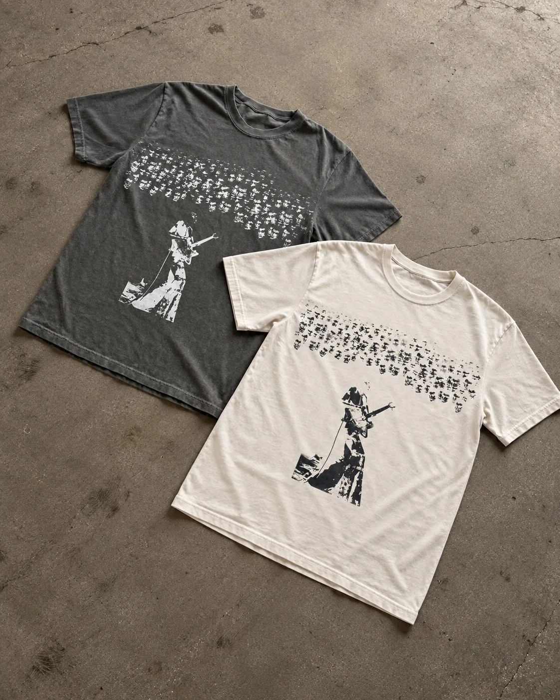 Studio composition of vintage-wash and cream Band1 tees overlapping on concrete