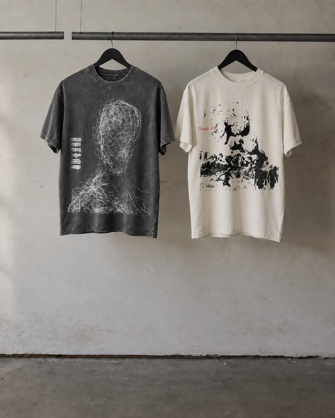 Studio visualization of Stitches and 808s Dreams and cream Troubled front-print tees hanging on a steel rack