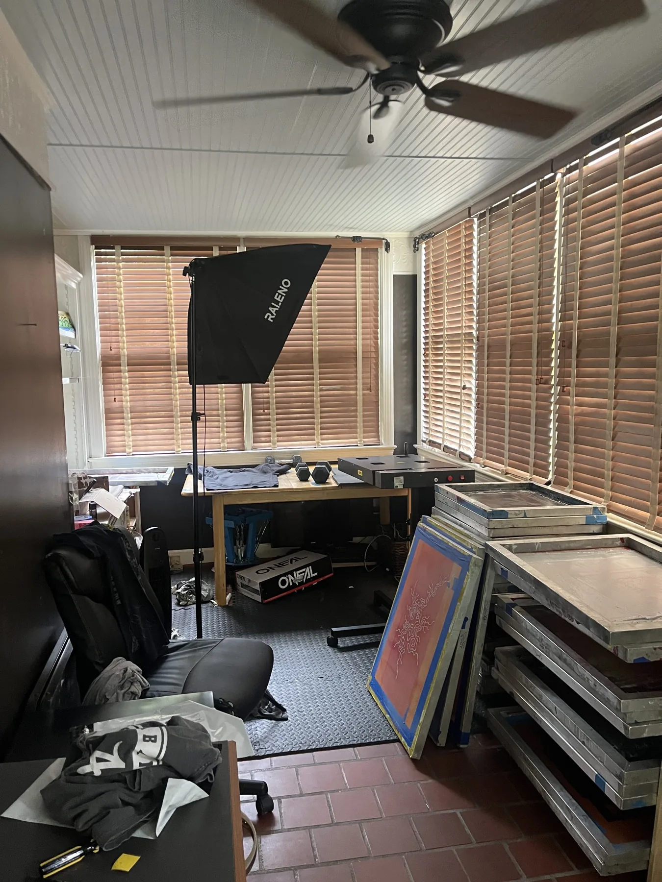The original Stitches and 808s studio with print screens, a work table and photography light